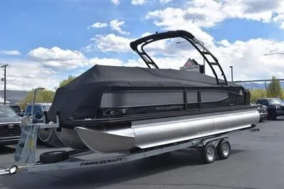 Slide: The Image of 2026 Princecraft Quorum 25 RL pontoon boat on trailer, covered, parked outdoors. - 29