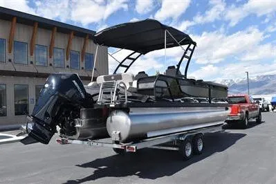 Slide: The Image of 2026 Princecraft Quorum 25 RL pontoon boat on trailer, parked outdoors. - 3