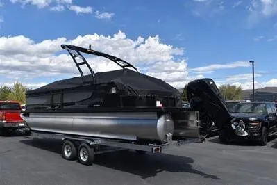 Slide: The Image of 2026 Princecraft Quorum 25 RL pontoon boat on trailer under blue sky. - 30