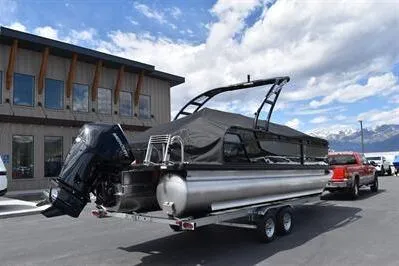 Slide: The Image of 2026 Princecraft Quorum 25 RL pontoon boat on trailer, parked outdoors. - 32