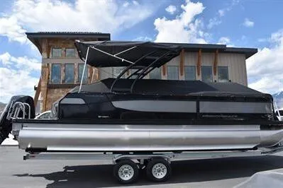 Slide: The Image of 2026 Princecraft Quorum 25 RL pontoon boat with canopy, parked outdoors under a blue sky. - 33
