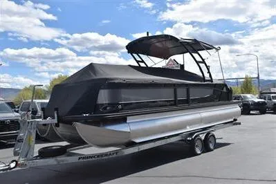 Slide: The Image of 2026 Princecraft Quorum 25 RL pontoon boat on trailer under a clear blue sky. - 34
