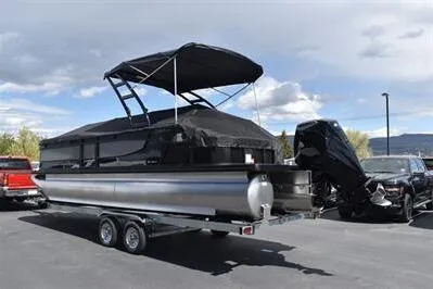 Slide: The Image of 2026 Princecraft Quorum 25 RL pontoon boat on trailer, featuring a sleek black canopy. - 36