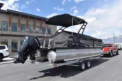 Slide: The Image of 2026 Princecraft Quorum 25 RL pontoon boat on trailer, parked outdoors. - 38