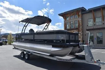 Slide: The Image of 2026 Princecraft Quorum 25 RL pontoon boat on trailer, parked outdoors. - 5