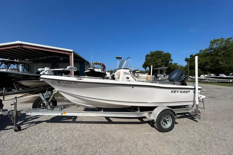 The Image of 2014 Key West 176 Sportsman CC boat on trailer under clear blue sky. - 1