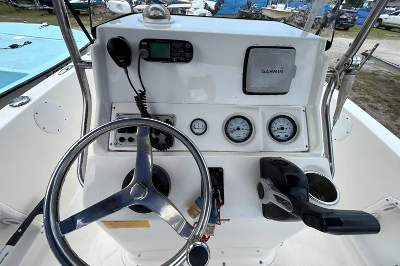Slide: The Image of 2014 Key West 176 Sportsman CC boat console with steering wheel, gauges, and Garmin device. - 11