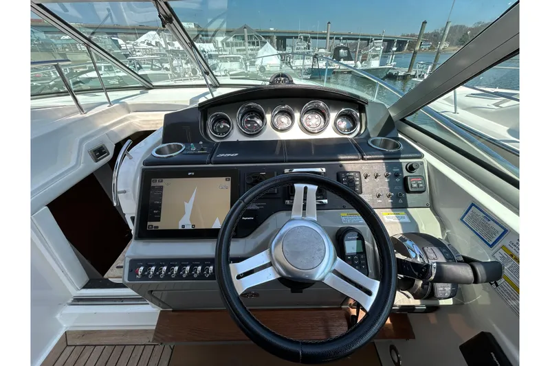 Slide: The Image of Cockpit of 2014 Sea Ray Sundancer 350 with navigation controls and steering wheel. - 10
