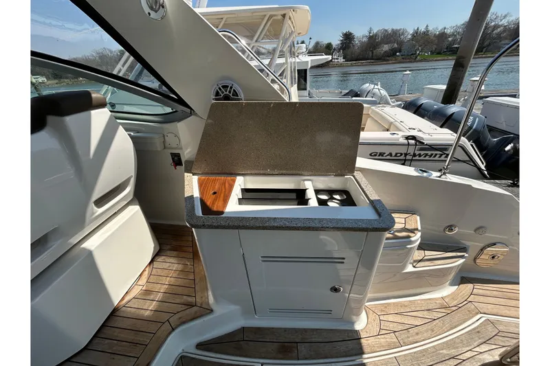 Slide: The Image of 2014 Sea Ray Sundancer 350 boat interior with kitchenette and wooden flooring. - 6