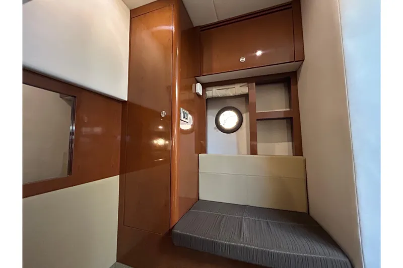 Slide: The Image of Interior cabin of 2014 Sea Ray Sundancer 350 with wood paneling and porthole window. - 16