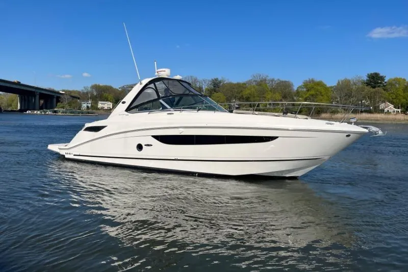 The Image of 2014 Sea Ray 350 Sundancer yacht cruising on a calm river under a clear blue sky. - 0