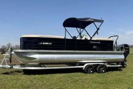 The Image of 2022 Veranda Vista View22RC TT pontoon boat on trailer in grassy field. - 1