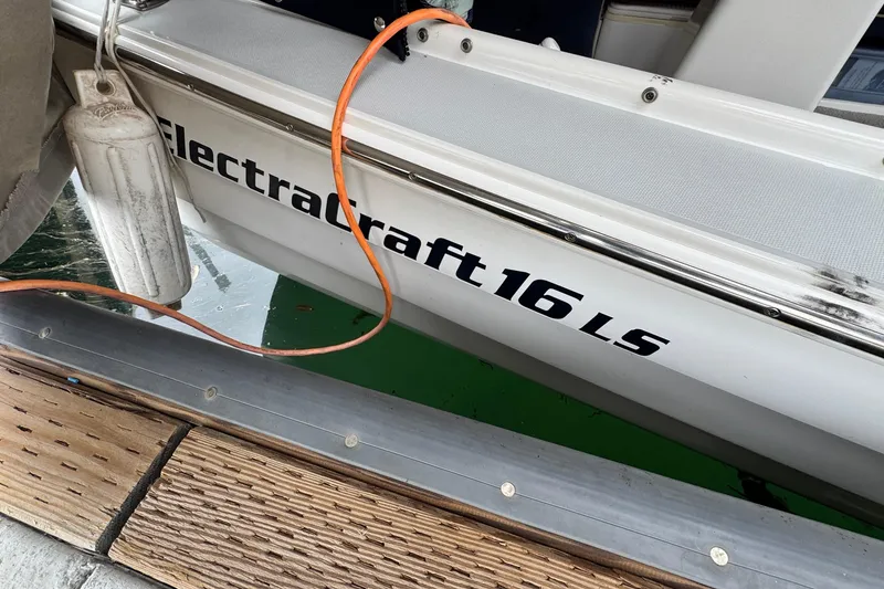 Slide: The Image of 2003 ElectraCraft 16 LS boat docked with visible fender and orange cable. - 4