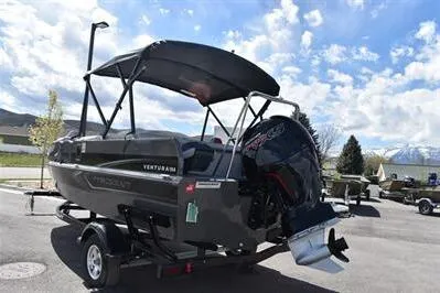 Slide: The Image of 2026 Princecraft Ventura 194 boat with canopy and outboard motor in a parking lot. - 5