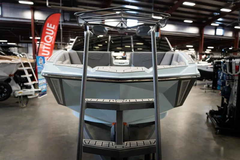 Slide: The Image of 2026 Nautique G23 boat in showroom with ladder. - 8