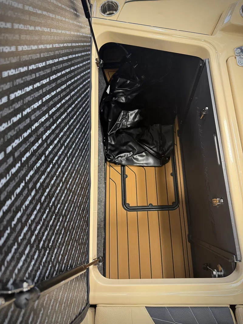 Slide: The Image of Interior of 2026 Nautique Super Air Nautique S23 with storage compartment. - 15