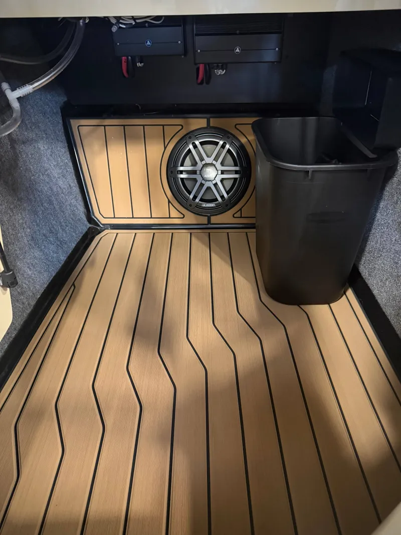 Slide: The Image of Interior of 2026 Nautique Super Air Nautique S23 with speaker and trash bin. - 16
