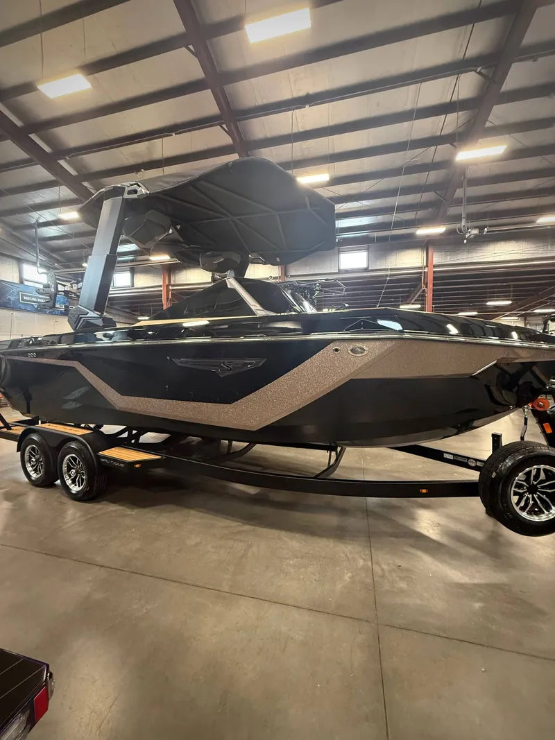 Slide: The Image of 2026 Nautique Super Air Nautique S23 boat in a warehouse. - 2