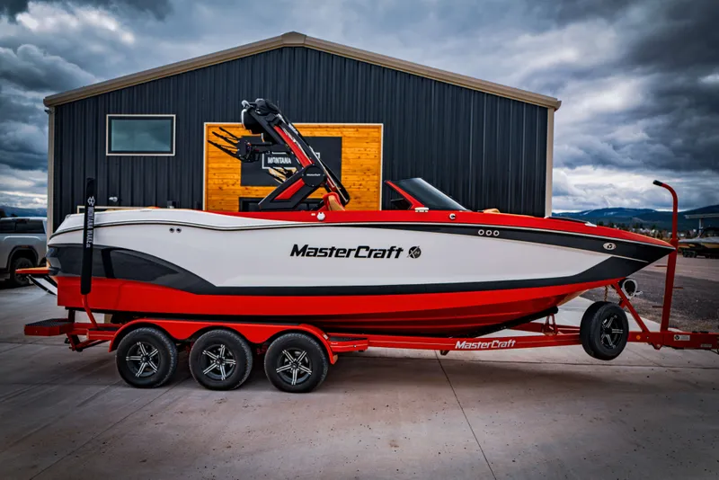 Slide: The Image of 2023 MasterCraft X24 boat on trailer in front of building. - 3