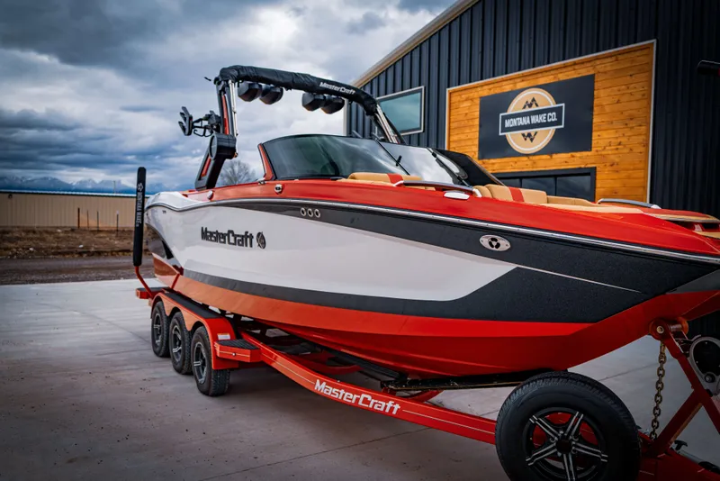 Slide: The Image of 2023 MasterCraft X24 boat in front of a building with cloudy sky. - 8