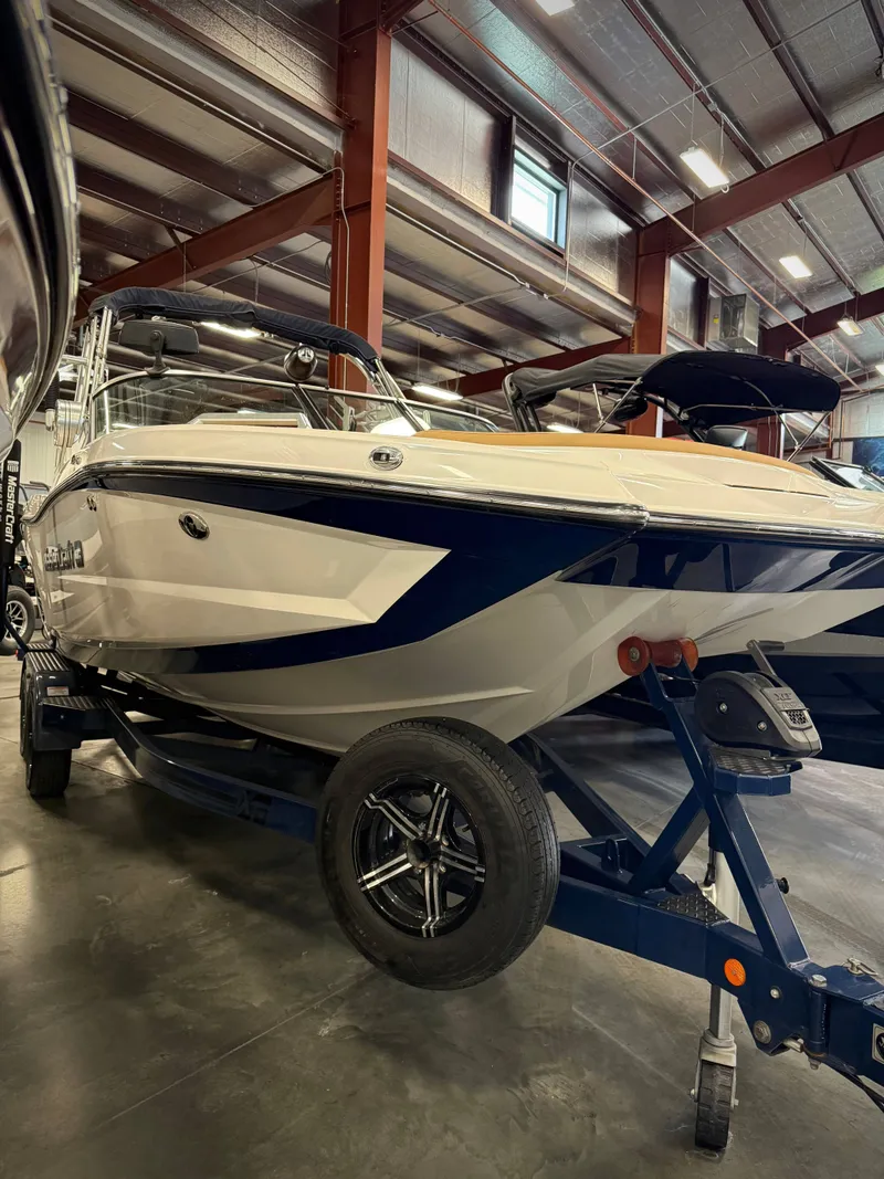 Slide: The Image of 2021 MasterCraft XT22 boat in a warehouse setting. - 2