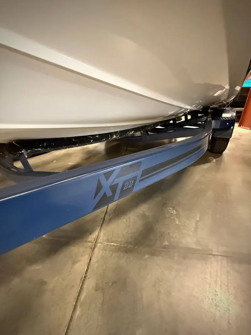 Slide: The Image of 2021 MasterCraft XT22 boat on trailer in garage. - 23