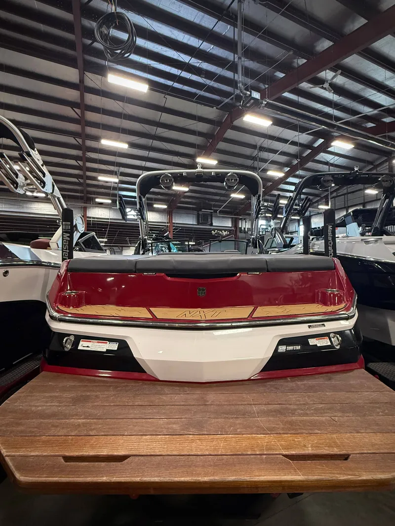 Slide: The Image of Red 2022 MasterCraft NXT24 boat in indoor storage. - 4