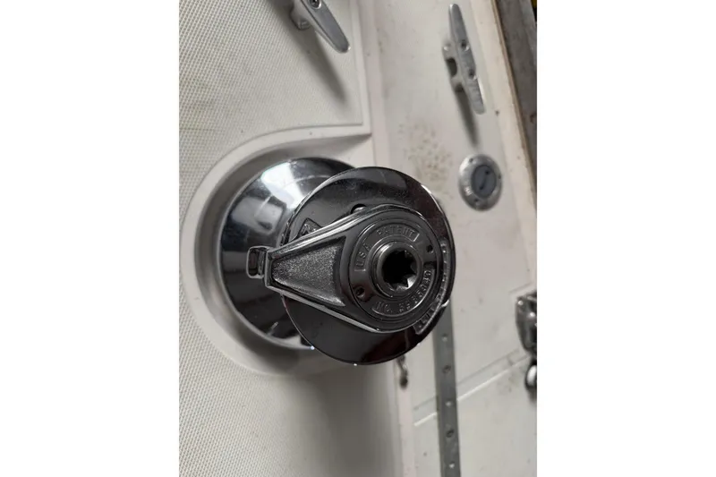 Slide: The Image of Close-up of a 1986 CAL 33 sailboat winch on a textured deck surface. - 13