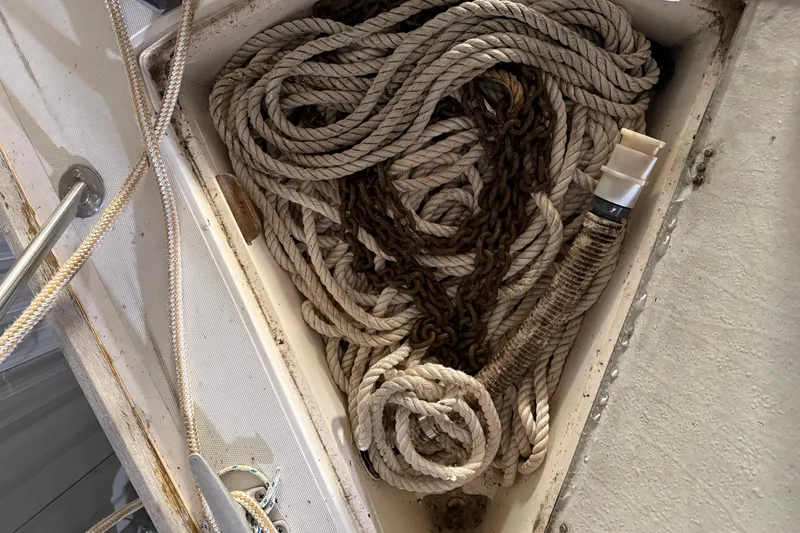 Slide: The Image of Coiled ropes and chain in a 1986 CAL 33 sailboat compartment. - 19