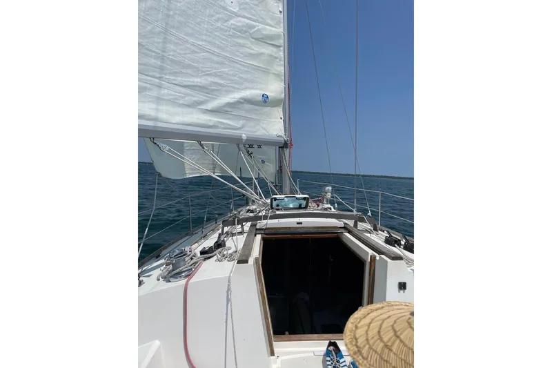 Slide: The Image of Sailing on a 1986 CAL 33 yacht with open cabin and clear blue skies. - 2