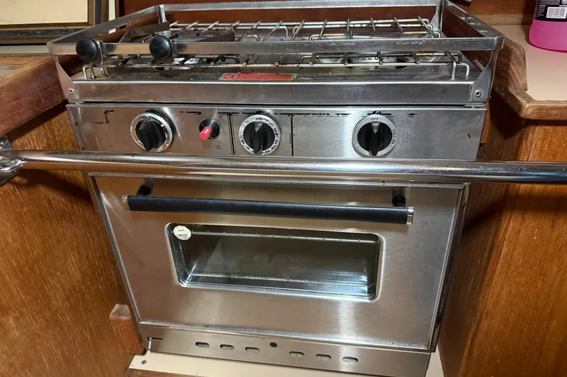Slide: The Image of Stainless steel stove with three knobs, CAL 33 model, 1986, in a wooden kitchen setting. - 22