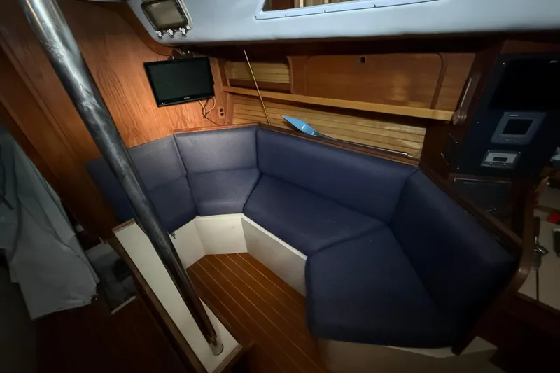 Slide: The Image of Interior of 1986 CAL 33 sailboat with blue seating and wooden accents. - 24
