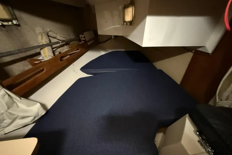 Slide: The Image of Interior cabin of a 1986 CAL 33 sailboat with blue cushions and wooden accents. - 26