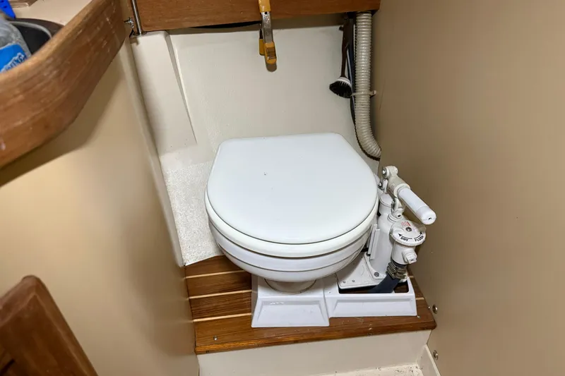 Slide: The Image of Marine toilet in a 1986 CAL 33 sailboat bathroom, featuring manual pump system. - 30