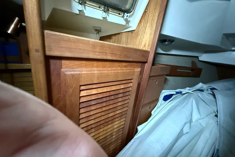 Slide: The Image of Interior of a 1986 CAL 33 sailboat featuring wooden cabinetry and storage space. - 31