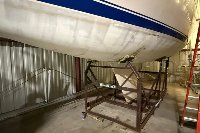 Slide: The Image of 1986 CAL 33 sailboat hull on stand in indoor storage facility. - 4