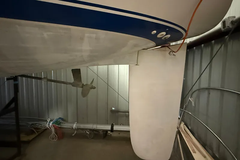 Slide: The Image of 1986 CAL 33 sailboat keel and propeller in storage, showcasing hull details. - 6