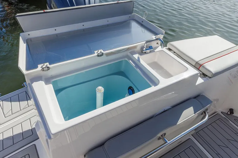 Slide: The Image of Manufacturer Provided Image: 2025 Solara S-250 Coupe boat with open storage compartment by the water. - 18