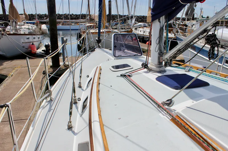 Slide: The Image of 1989 Catalina 36 sailboat docked at marina, showcasing deck and rigging. - 10