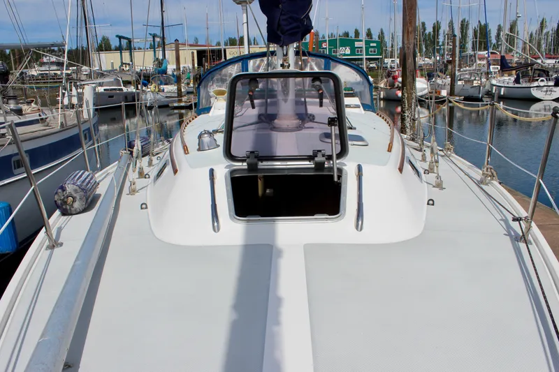 Slide: The Image of 1989 Catalina 36 sailboat deck view in marina, open hatch, surrounded by other boats. - 14