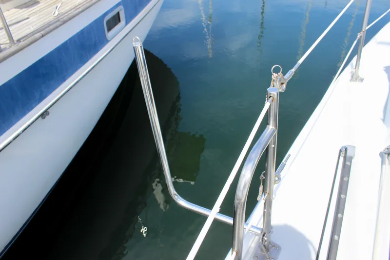 Slide: The Image of 1989 Catalina 36 sailboat deck with stainless steel railing and calm water reflection. - 18