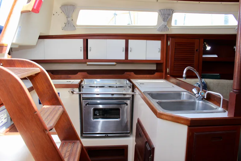 Slide: The Image of Interior of 1989 Catalina 36 sailboat kitchen with wooden cabinetry and stainless steel appliances. - 31