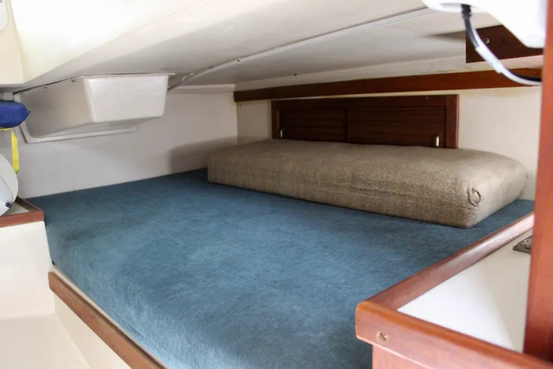 Slide: The Image of Interior cabin of a 1989 Catalina 36 sailboat with blue and beige bedding. - 37