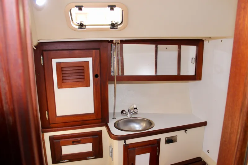 Slide: The Image of 1989 Catalina 36 yacht interior with wooden cabinetry and compact sink area. - 50