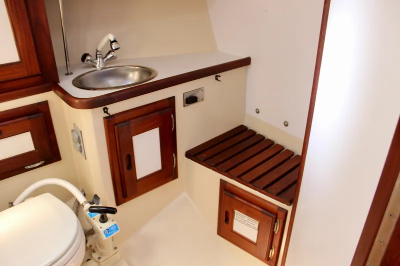 Slide: The Image of 1989 Catalina 36 yacht bathroom with sink, wooden cabinets, and marine toilet. - 52