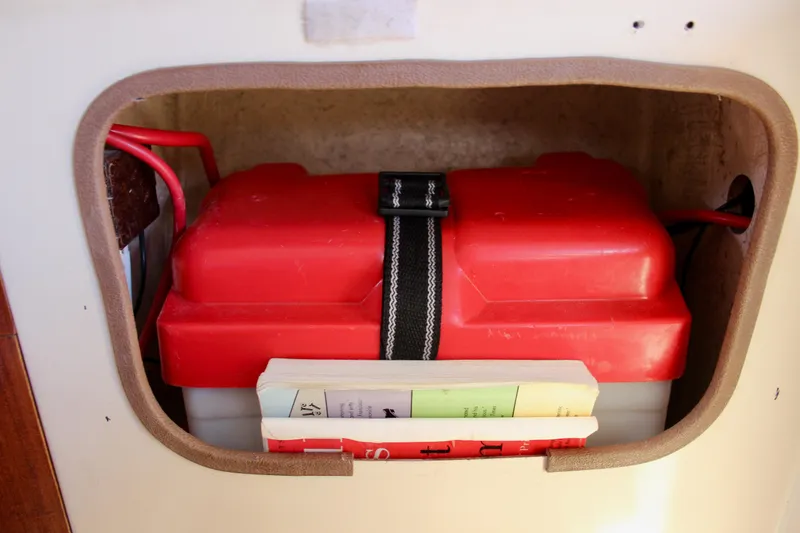 Slide: The Image of Battery compartment of a 1989 Catalina 36 sailboat with red cover and books. - 57
