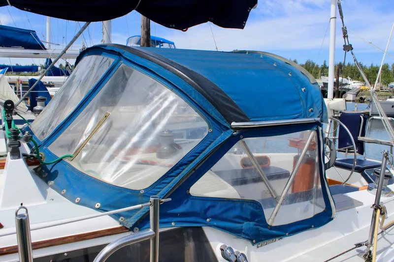 Slide: The Image of 1989 Catalina 36 sailboat with blue canvas cover docked at marina. - 6