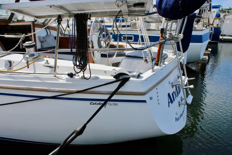 Slide: The Image of Catalina 36 sailboat from 1989 docked at a marina, featuring a clean white hull. - 8