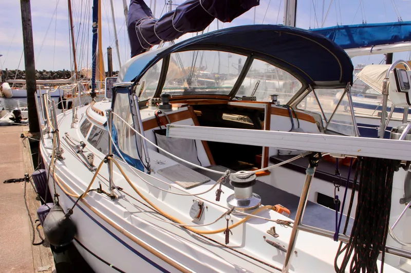 Slide: The Image of 1989 Catalina 36 sailboat docked at marina, featuring spacious cockpit and rigging. - 9
