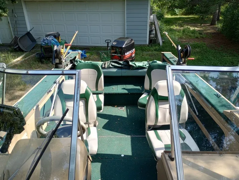 Slide: The Image of Interior view of a 1998 Lund 1900 Tyee boat with green seats. - 2